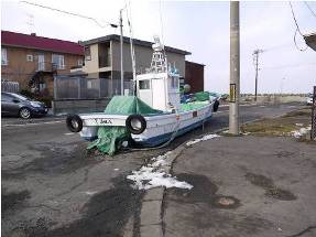 Fishing boat carried brought ashore by the storm surge
